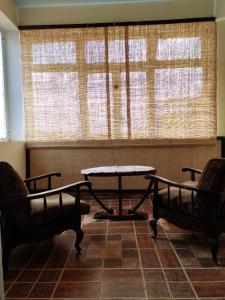 a room with two chairs and a table and a window at Résidence Tianay in Antananarivo