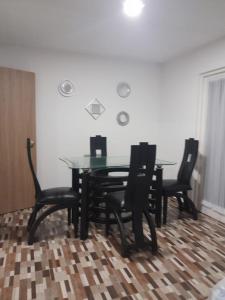 a dining room with a glass table and chairs at Hanna's House. in Villavicencio