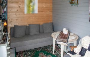 a couch in the corner of a room with two tables at 2 Bedroom Stunning Home In Skotterud in Magnor +7 photos