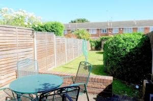 a patio with a table and chairs and a fence at Victoria Road, comfortable 3 bedroom houses with fast Wi-Fi in Sittingbourne