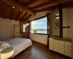 - une chambre avec un lit et une grande fenêtre dans l'établissement Villa Riflessi - Manerba del Garda, à Manerba del Garda