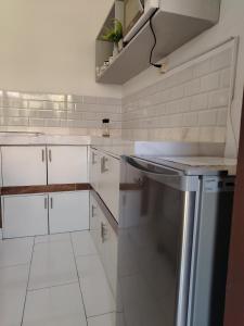 eine weiße Küche mit weißen Schränken und einem Geschirrspüler in der Unterkunft departamento en la mejor zona de cochabamba in Cochabamba