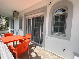 Un patio con una mesa y sillas y una ventana. en Elisabeth Apartments, en Sarandë