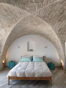 a bedroom with a bed in a brick wall at Palazzo Finzi Carriero in Campomarino