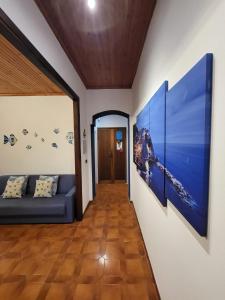 a hallway with a couch and paintings on the wall at Casa LA MARINA in Manarola