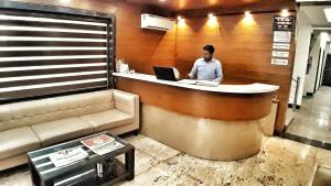 a man sitting at a counter with a laptop at Hotel Delhi Aerocity in New Delhi