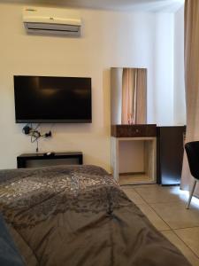 a bedroom with a bed and a flat screen tv at Gentle Breeze Studio 1 in Amman