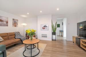 a living room with a couch and a table with flowers at MODERN Comfortable HOUSE in Peterborough