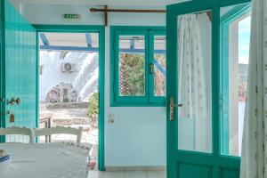 uma porta que leva a um pátio com uma mesa em Patras Apartments em Fourni Ikarias