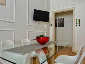 ein Esszimmer mit einem Glastisch und einem TV in der Unterkunft 2 Bedroom, 2 Bathroom - Palma Residence in Lissabon