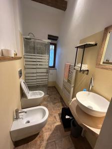 a bathroom with two sinks and a shower and a toilet at Borgo di Mezzo in Castelnuovo dellʼAbate