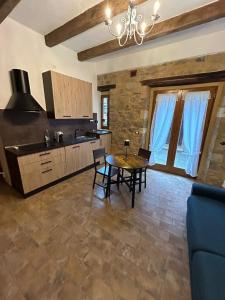 a kitchen with a table and chairs in a room at Borgo di Mezzo in Castelnuovo dellʼAbate