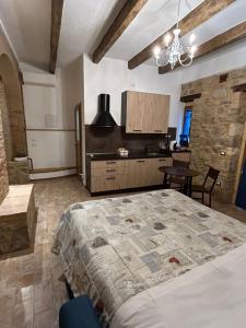 a bedroom with a large bed and a kitchen at Borgo di Mezzo in Castelnuovo dellʼAbate