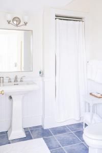 Baño blanco con lavabo y aseo en Relaxing guesthouse with pool, stunning views close to beach, en Nantucket