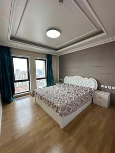 - une chambre avec un lit dans une pièce dotée de fenêtres dans l'établissement Classic apartment at Circus, à Oulan-Bator