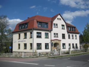 un gran edificio blanco con techo rojo en FEWO mit Sauna & Gartenblick en Neustadt in Sachsen