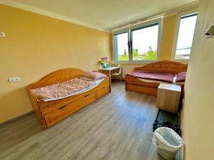 um quarto com 2 camas, uma mesa e janelas em Aurora Iris em Praga