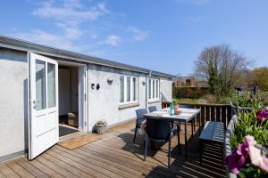 a patio with a table and chairs on a deck at Cozy Apartment Stevns in Store Heddinge