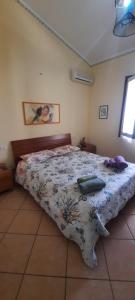 a bedroom with a bed with a floral comforter at Zurrundeddu House in Pula