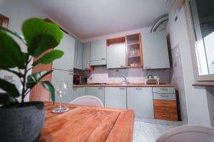 a kitchen with a wooden table and white cabinets at Perla del Mare in Cesenatico