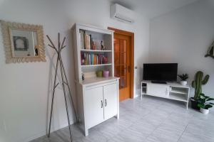 a living room with a tv and a book shelf at Perla del Mare in Cesenatico