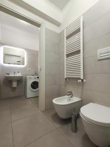 y baño con lavamanos y lavadora. en YR Apartments Milan - Navigli - Pizza&Pasta Apartment, en Milán