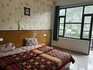 um quarto com uma cama e uma grande janela em Marina trail em Dharamshala