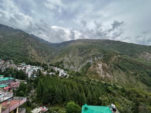 uma vista para uma montanha com casas e árvores em Marina trail em Dharamshala