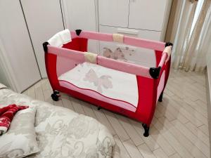 B&B MaryGe في إيركولانو: سرير اطفال احمر وبيض في غرفة بسرير