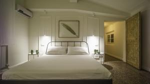 a bedroom with a large white bed with two lamps at Luxury Apartment in Palazzo Spada in Bologna