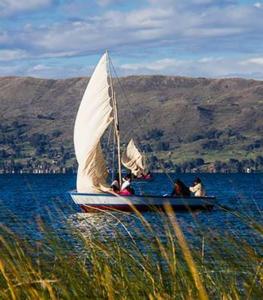a group of people on a sail boat in the water at TITICACA'S SALA UTA in Puno