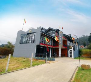 un gran edificio con banderas delante en Windsor Residence, en Nuwara Eliya