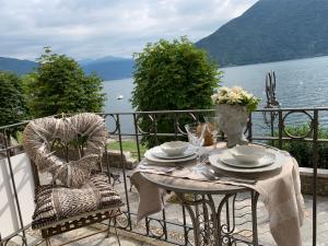 una mesa en un balcón con vistas al agua en Spiaggia Amore - Appartamenti Vacanza Vista Lago en Cannobio
