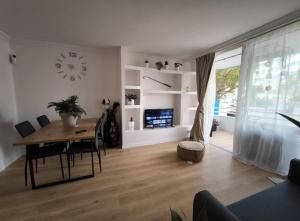 a living room with a dining room table and a clock at Golf vila3 in San Miguel de Abona