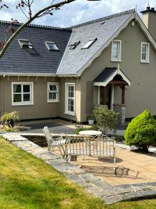 una casa con una panchina e un tavolo di fronte ad essa di The Lodge Donegal Town a Donegal