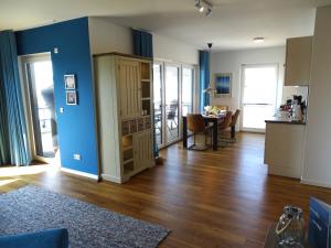 a living room with a blue wall and a table at Gode Wind Quartiere 8 in Dahme