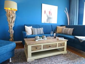 a blue living room with a blue couch and a coffee table at Gode Wind Quartiere 8 in Dahme