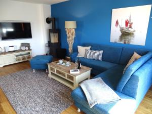 a blue living room with a blue couch and a table at Gode Wind Quartiere 8 in Dahme
