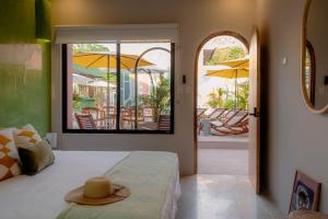 Un dormitorio con una cama con un sombrero encima. en Hotel Amavi, en Jacó