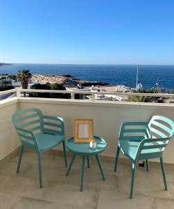two chairs and a table on a balcony with the ocean at Puglia Dreaming seaview apartment in Polignano a Mare
