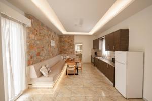 a kitchen with a couch and a table and a refrigerator at Loukas & Emma Houses in Perissa