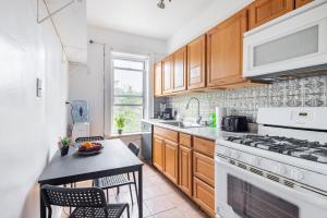 a kitchen with wooden cabinets and a white stove top oven at KLO Guest House in Brooklyn