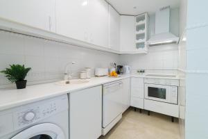 a white kitchen with a sink and a dishwasher at Marbella Este Next Marriott and Nikki B - Happy Rentals in Marbella