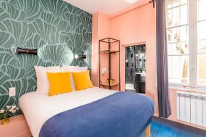 パリにあるLuxury 3 Bedroom 2 Bathroom Family Loft in Centralのベッドルーム1室(オレンジ色の壁のベッド1台、黄色の枕付)