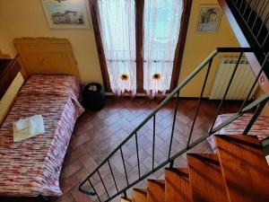 une chambre avec un lit et un escalier avec une fenêtre dans l'établissement La Capanna - Stone House, à Lucques