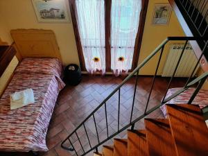 a room with a bed and a staircase with a window at La Capanna - Stone House in Lucca