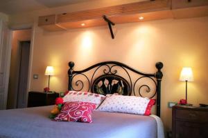 - une chambre avec un lit doté d'oreillers roses et blancs dans l'établissement La Capanna - Stone House, à Lucques