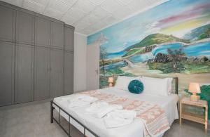 Schlafzimmer mit einem Bett mit Wandgemälde in der Unterkunft Villa D'Arte in Kalipádhon