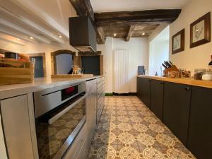 cocina con armarios negros y suelo de baldosa en Country house 'Un der Attert', en Boevange-sur-Attert