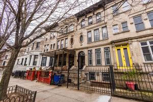 a building with a yellow door on a city street at KLO Guest House in Brooklyn